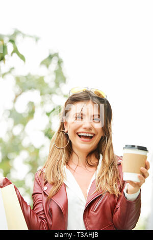 Pretty woman with coffee standing outdoors Stock Photo