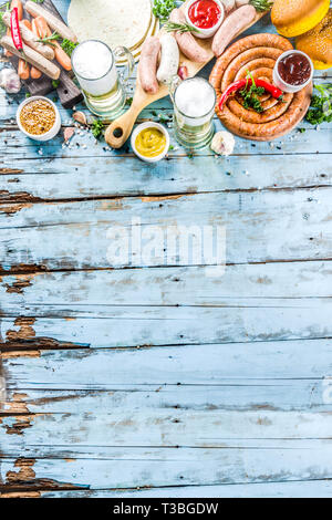 Different bbq picnic party food with beer  various grilled sausages, burger buns, flat taco bread, beer, old wooden background copy space