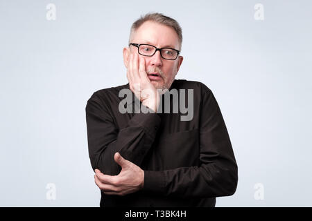 Senior european man thinking about his problems, expressing some doubts about decisions. Stock Photo