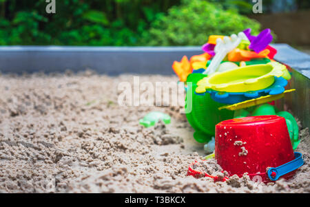 Close up of colorful toys on sand playground. Sandbox and set of color plastic toys. Stock Photo