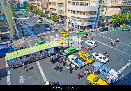TEHRAN, IRAN - OCTOBER 25, 2017: Busy traffic on the intersection of Amir Kabir and Pamenar streets, yellow and green taxies and public buses drive in Stock Photo