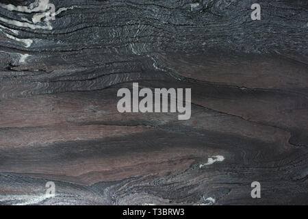 Natural dark stone with beautiful patterns called Rosso Luana quartzite. Stock Photo