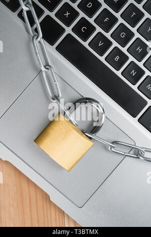 Padlock with chain on a laptop computer keyboard. Cyber security abstract concept. Stock Photo