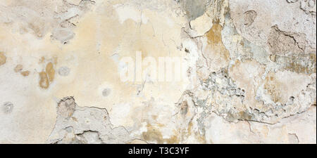 Old Wall With Peel Grey Stucco Texture. Retro Vintage Worn Wall Background. Decayed Cracked Rough Abstract Banner Surface. Stock Photo