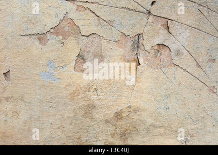 Textured grunge background. Old plastered wall with a multilayer cracked coating. Grunge texture with a deep pattern on beige wall Stock Photo