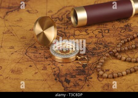 Old vintage retro compass and spyglass on ancient world map. Vintage ...