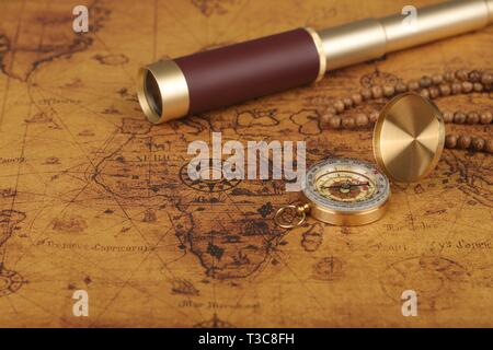 Vintage compass and spyglass on old world map - adventure stories ...