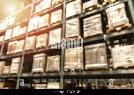 Logistic industry ,Asset warehouse and inventory management supply chain technology concept. Blur group of boxes in storehouse with flarelight. Stock Photo
