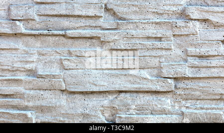 The old stone mosaic made of sandstone is painted with gray lime Stock Photo