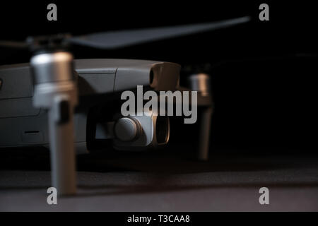 Close-up of the front section of a DJI Mavic 2 Pro drone showing the propeller and camera, with focus on the camera. Studio shot with copy space. Stock Photo