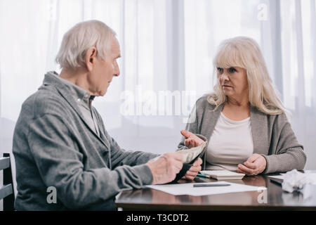 senior couple having discussion while sitting at table with paperwork Stock Photo