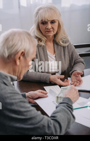 senior couple having discussion while sitting at table with paperwork Stock Photo