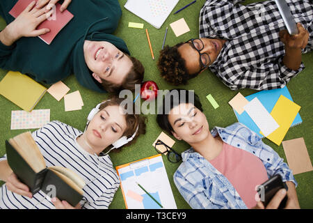 Modern students using gadgets and reading books Stock Photo