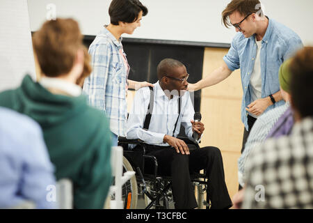 Disabled black man in wheelchair giving lecture at conference Stock Photo