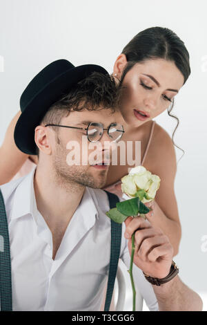 handsome man in black hat and glasses gifting rose to beautiful girl Stock Photo