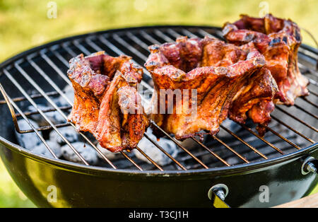 Baby Back Ribs Crown Roast on BBQ barbecue kettle grill. Home made pork crown ribs on a grill using low and slow method. Grilling outdoors in nature a Stock Photo