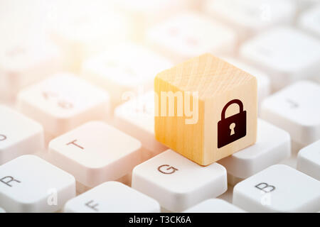 Wooden block with lock graphic on computer keyboard. Computer security concept. Stock Photo