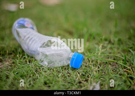 Discarded plastic water bottle on green grass field. Stock Photo
