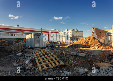 The ruins of a destroyed building in the city against the backdrop of a blue sky. Stock Photo