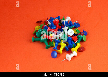 color push pins on orange background Stock Photo
