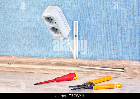 Duplex power outlet with screwdriver and wire stripper cutter near it. Stock Photo