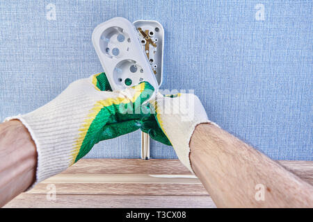 Worker is putting new           pattress box on wall outlet,  installing euro wall plug socket. Stock Photo