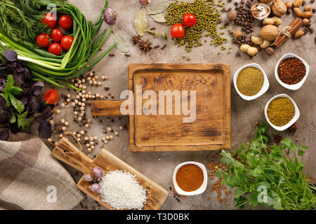 Fresh greens and tomatoes spices cereals and nuts organic healthy snacks on a textural background. Concept of healthy food. Frame under the text. Stock Photo