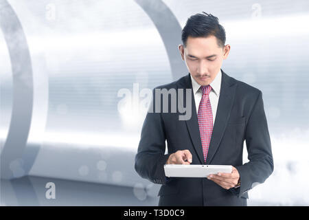 Handsome asian businessman using digital tablet in his hand. Future technology concept Stock Photo