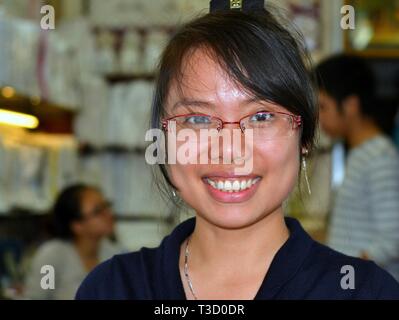 Young Vietnamese businesswoman with modern eyeglasses smiles for the camera. Stock Photo