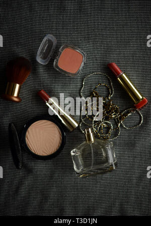two lipsticks, perfume bottle, necklace, blusher and face powder