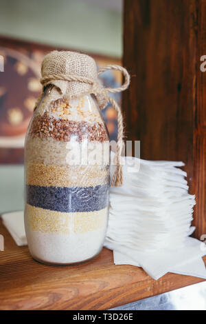 Cereal pots and breakfast bowls in a hotel on wooden board Stock Photo