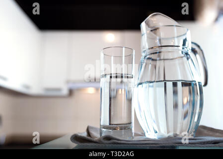 A glass of fresh water with crafin on the background of a modern kitchen. Stock Photo