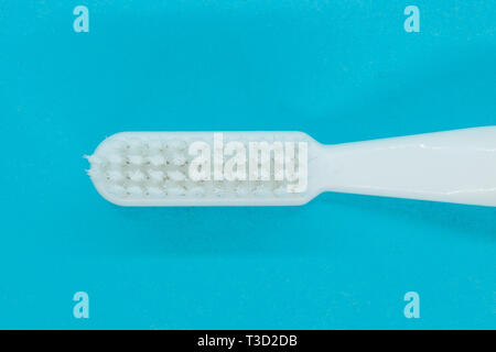Top view of white toothbrush on blue background Stock Photo