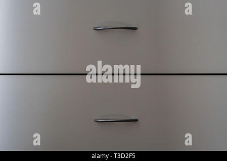 Two closed sliding wooden drawers with metal handles Stock Photo