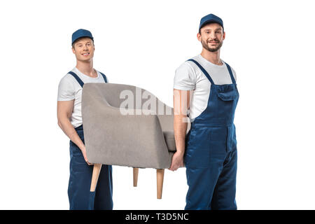 two movers looking at camera and transporting grey armchair isolated on white Stock Photo