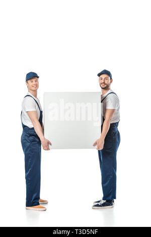 two smiling movers looking at camera while holding blank box isolated on white Stock Photo