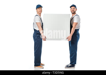 two smiling movers looking at camera while holding blank box isolated on white Stock Photo
