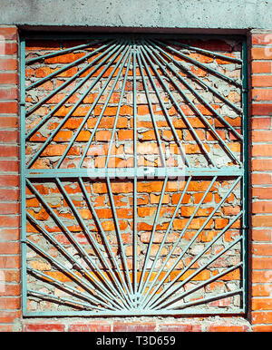Shabby Building Facade Of Brick Wall With Damaged Crack And Immured Window with window painted grill Stock Photo