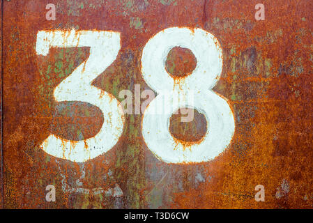 Texture of old completely rusty metal with number theerty eight drawn by white paint Stock Photo