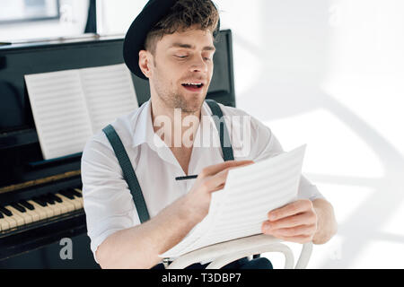 selective focus of cheerful man composing music at home Stock Photo