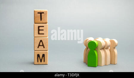 Wooden blocks with the word Team and a crowd of workers with a leader. The concept of a strong reliable business team. Teamwork. Team management. Choo Stock Photo