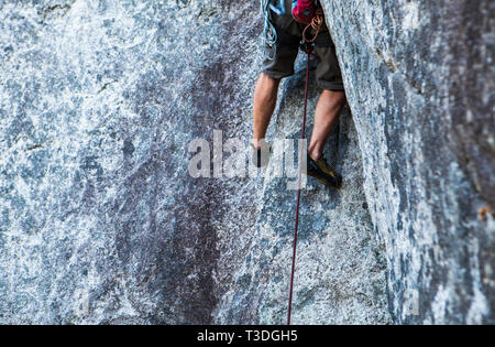 A male rock climber running it out (Climbing a long way without protecting the potential fall) in the Little Smoke Bluffs climbing area, Squamish, BC, Stock Photo