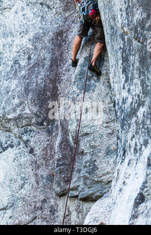 A male rock climber running it out (Climbing a long way without protecting the potential fall) in the Little Smoke Bluffs climbing area, Squamish, BC, Stock Photo