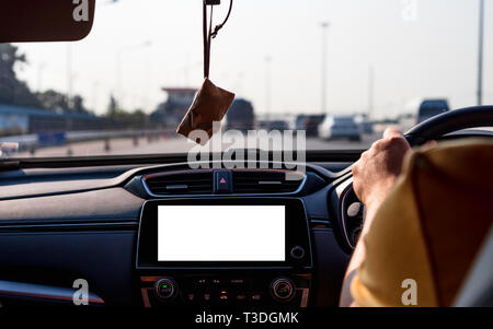 Mock up of Isolated blank screen monitor in car for your advertising. The man behind the wheel, driving in traffic with car radio mockup. Stock Photo
