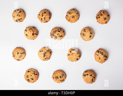 cookies with pieces of chocolate placed symmetrically on white background Stock Photo