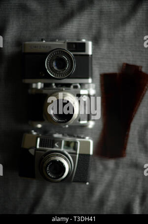 three antique vintage film cameras and film negatives
