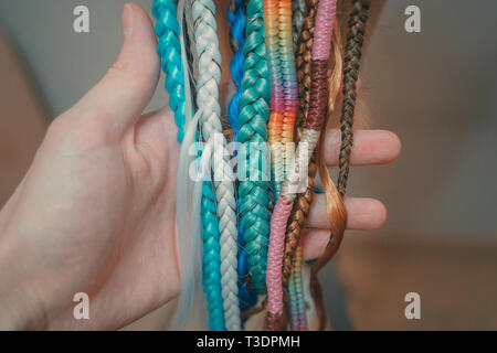 cornrows different braids learning to weave braids on a mannequin, weaving different harnesses from colored kanekalon Stock Photo