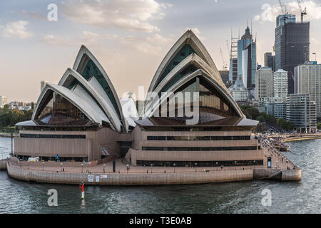 Sydney, Australia - February 12, 2019: Closeup of North side of the Opera House with highrises. Light Blue sky and gray water. Stock Photo