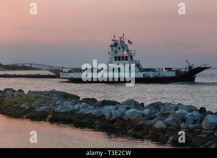 The Mobile Bay Ferry leaves Dauphin Island, Alabama, headed to Gulf Shores, Ala. and Fort Morgan, June 20, 2010, as the sun sets. Stock Photo