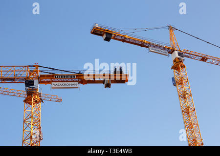 Stockholm, Sweden - September 13, 2018: Two yellow tower cranes in service for the Vasakronan property owner. Stock Photo